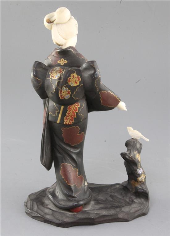 A Japanese ivory and lacquered wood okimono of a bijin feeding a bird, early 20th century, height 27cm